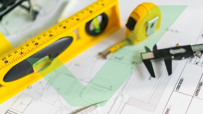 A tape measure, pencil, level and vernie calipers are placed on top of an architectural drawing with VAC Green tick